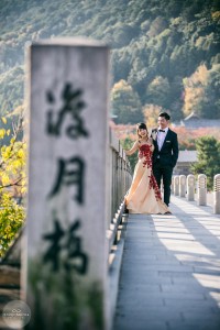 A couple dressed up posing on Togetsukyo bridge for pre-wedding photo