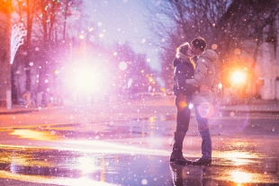 A couple kissing in snow in winter