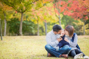 A happy family kissing their child for vacation photo