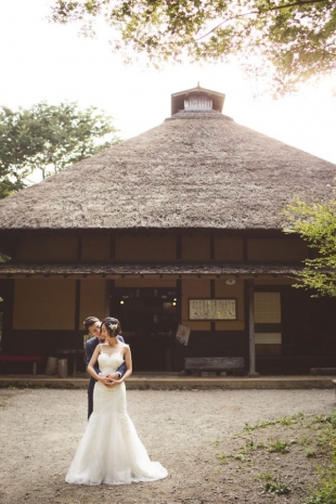 A couple cuddling in front of traditional Japanese house in Hakone for pre-wedding photo with CHiKA
