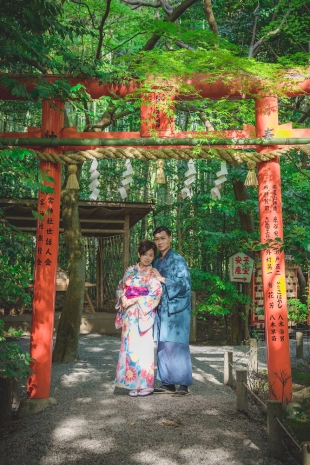 Vacation photo of a couple posing under the red torii in Kyoto