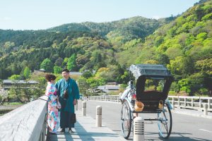 Vacation photo of a couple posing at Togetsukyo bridge in Arasshiyama, Kyoto