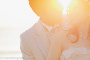A couple cuddling during sunset with woman wearing a wedding dress for pre-wedding photo