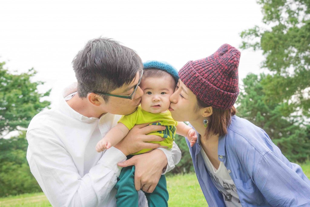 Mom and dad kissing the baby boy