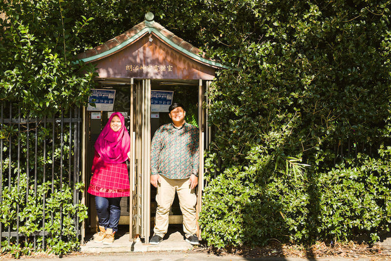 Vacation photo of a couple posing at a telephone booth in Yoyogi park, Tokyo