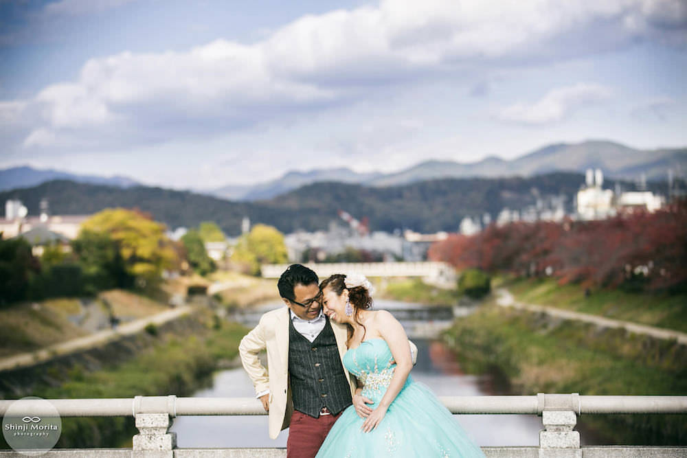 A couple dressed up for their pre-wedding photo with Kamogamo river in the background