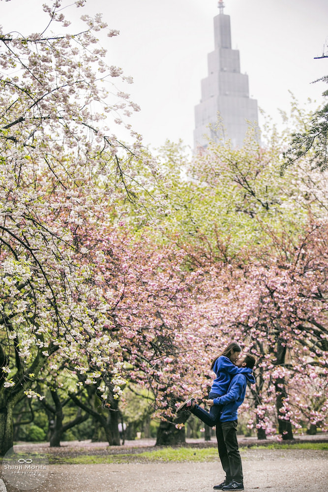 A couple hugging in Shinjuku Gyoen park during cherry blossom season