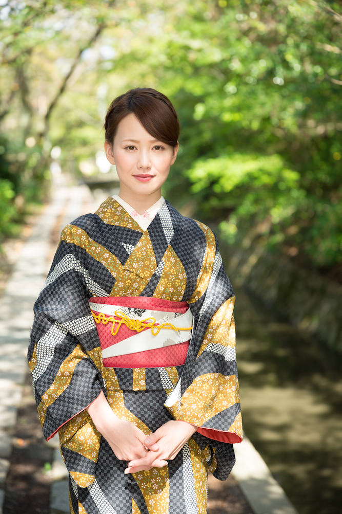 A woman posing with black and gold patterned kimono in Kyoto