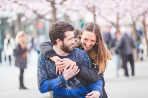 Couple hugging and being playful with cherry blossoms in the backgourd