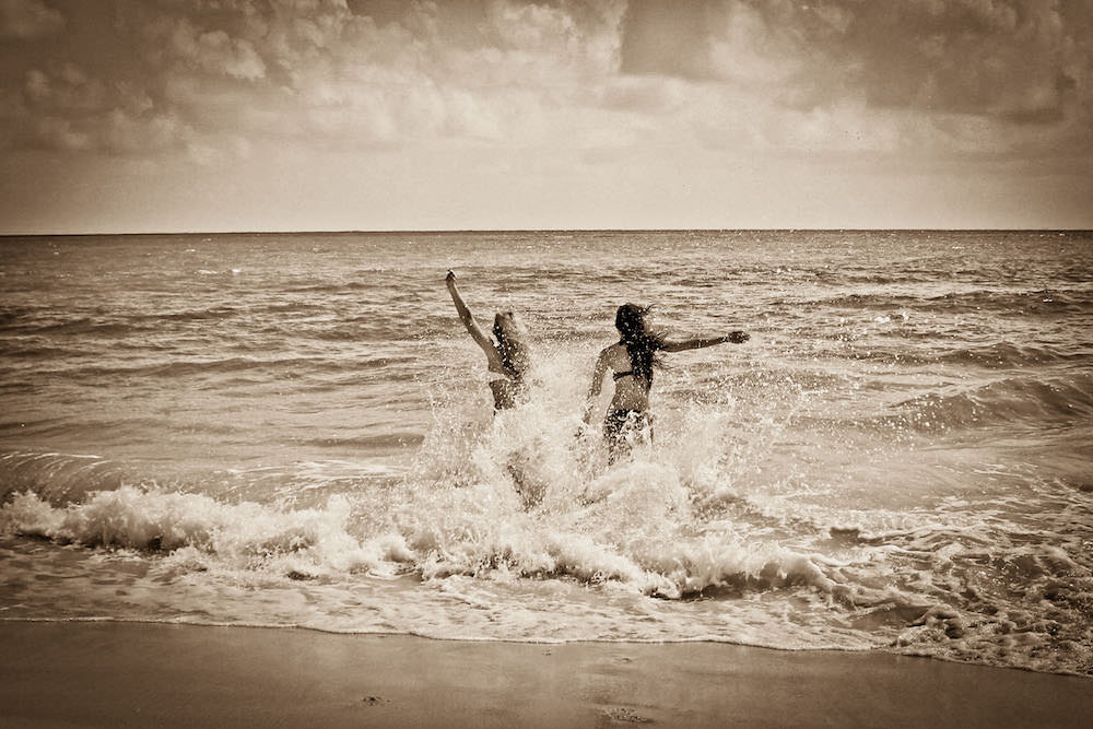 Vacation photo of two women being playful at the beach