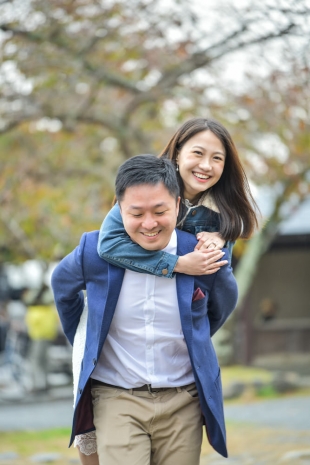 Vacation photo of a couple piggybacking in Arashiyama, Kyoto