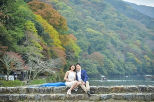 Vacation photo of a couple sitting by Hozu river in Arashiyama, Kyoto