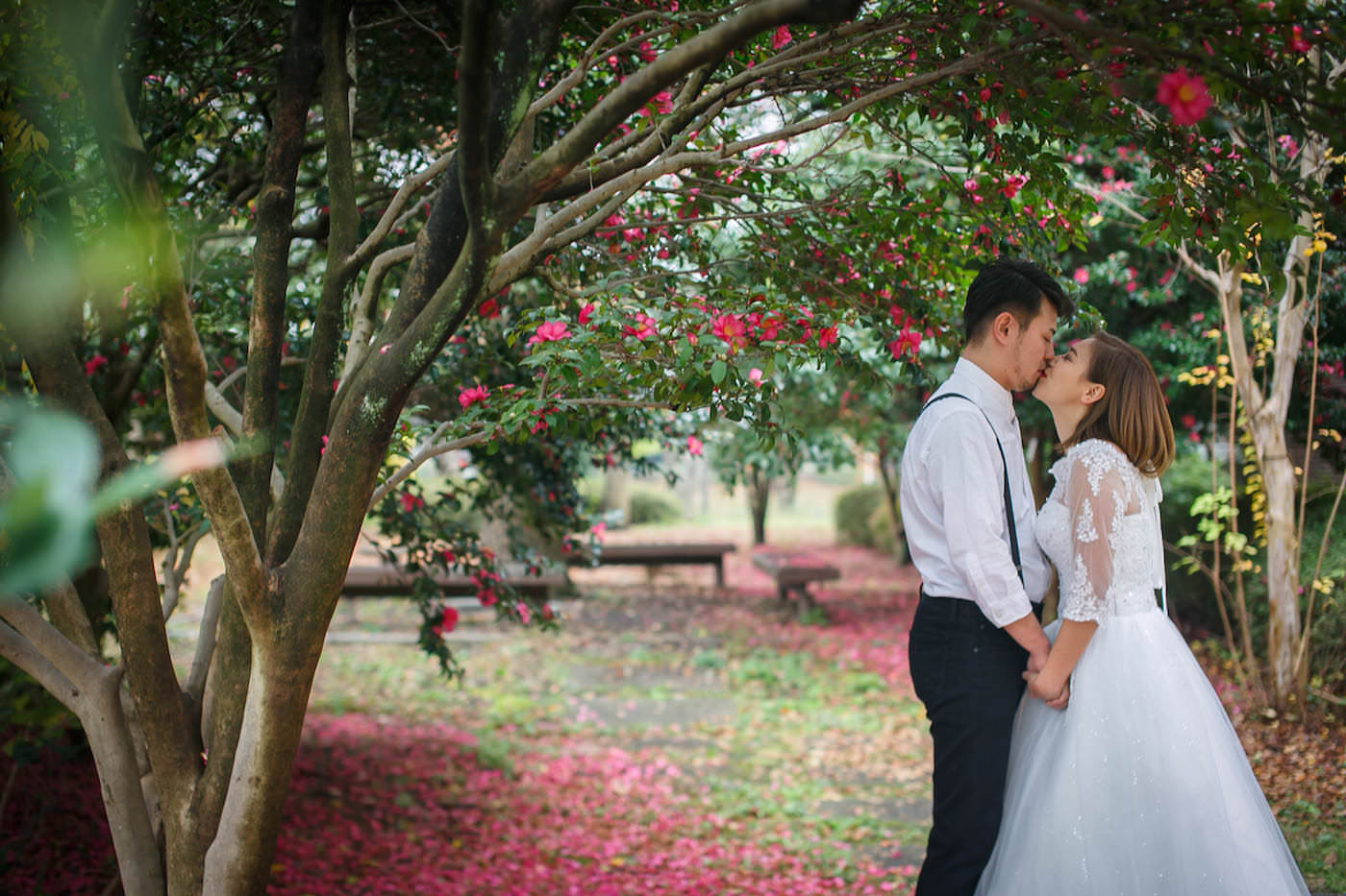 Pre-wedding photo by Ayako of a couple kissing at pink garden