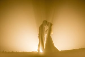 Photo by Masayuki of a couple kissing in beautiful ray of lights