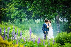 Photo by Masayuki of a couple kissing surrounded by beautiful flower garden at a park in Hokkaido