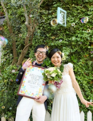 A couple smiling at the camera for vacation photo with Yoshiaki Ida