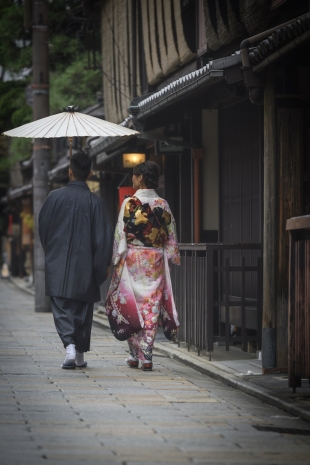 Pre-wedding photo of a couple strolling the street of Gion, Kyoto dressed in kimono