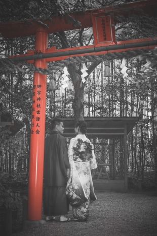 Pre-wedding photo of a couple posing at red torii at Arashiyama, Kyoto